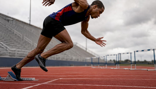 Athlete sprinting off starting blocks on track